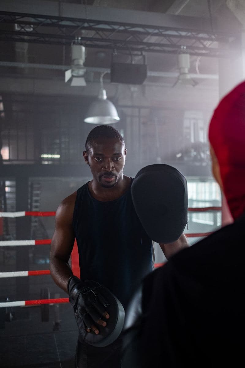 A boxing coach holding pads